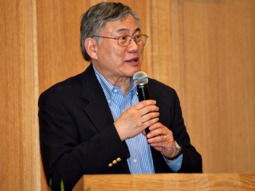 Roland Hwang, holding a microphone, during a lecture 