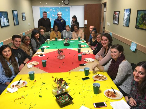 CGIS staff and students gathered around a decorated table enjoying the holidays spirit