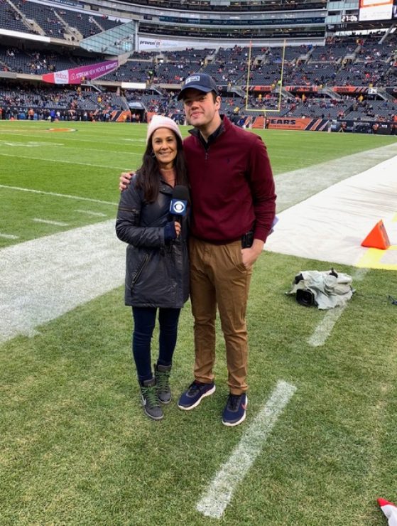 Student Benjamin Rosof and Tracy Wolfson on the sideline smiling at the camera