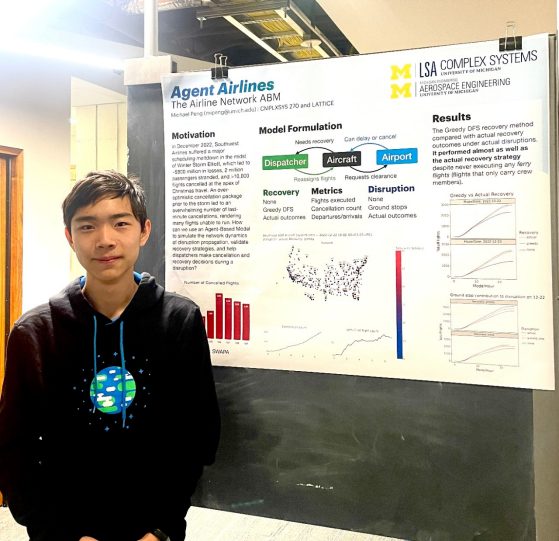 Michael Peng stands beside his poster on the Weiser 7th floor slate boards.