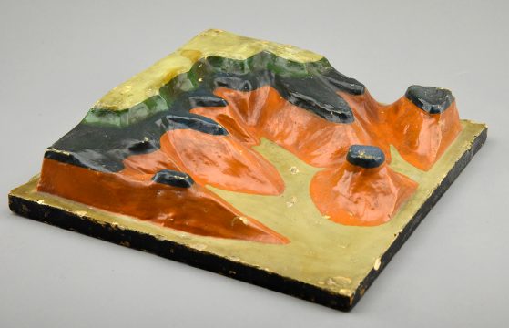 Photograph of colorfully painted plaster model of eroded landscape with rock layers defined in different colors, photo by Dale Austin