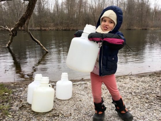 Duhaime's daughter, Aurora, helping to collect water samples from the Huron River. 