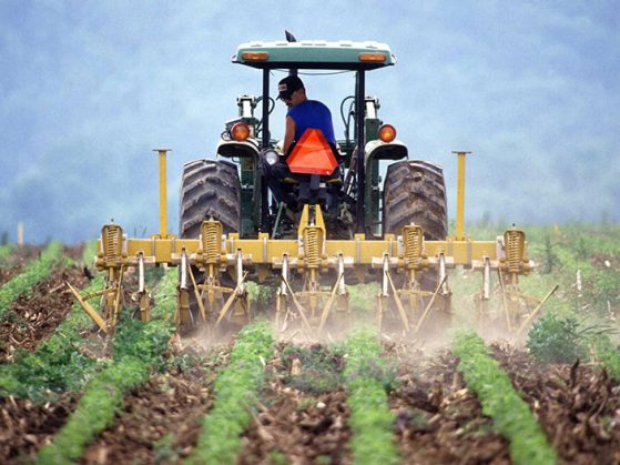 farmer tilling soil on tractor
