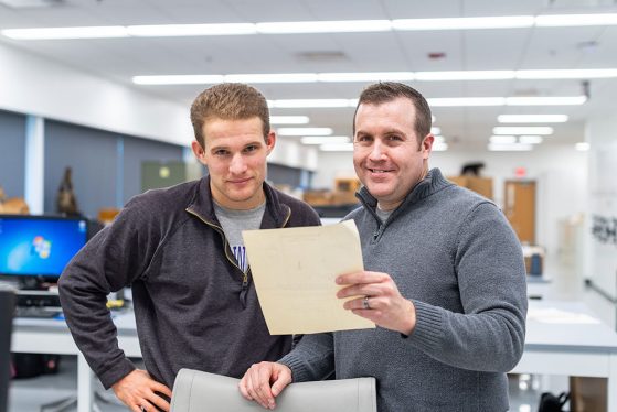 Clark Schmutz, left, and Cody Thompson examine a letter from the correspondence files of the Museum of Zoology mammal collections. 