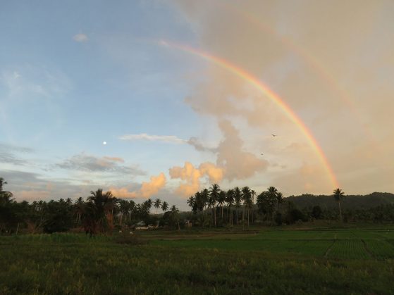 Double rainbow with moon, Cattle Egrets, and rice paddy fields, Padengo, Gorontalo, Indonesia on Sulawesi. Image: Eric Gulson