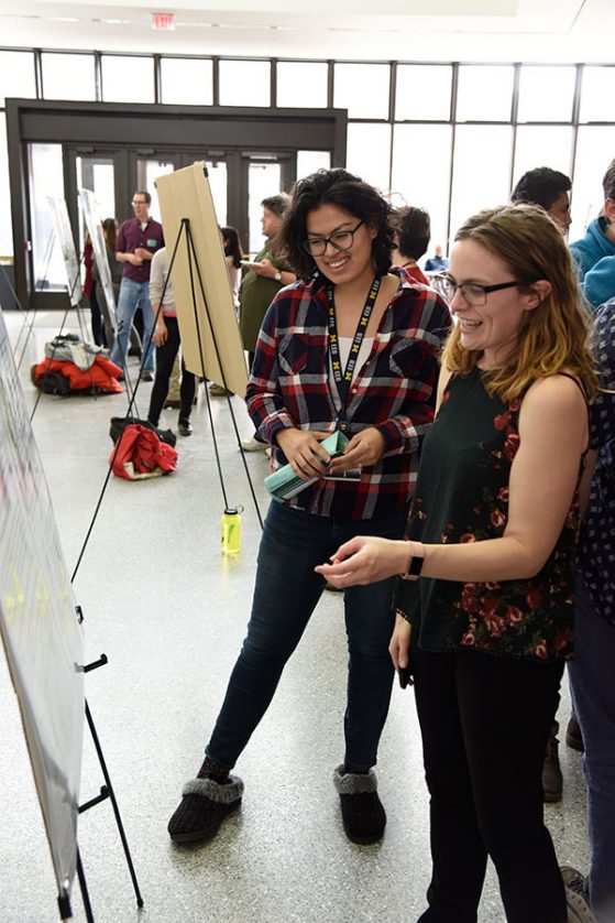EEB graduate student Susanna Campbell (left) explores the poster session. 