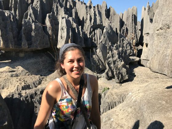María Natalia Umaña in Madagascar with a background of tall gray stone formations