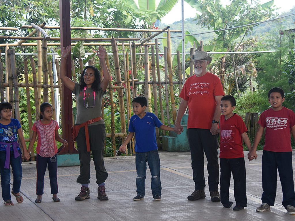 Ivette Perfecto (arms raised) and John Vandermeer play an ecological game with the children during Ecodía. 
