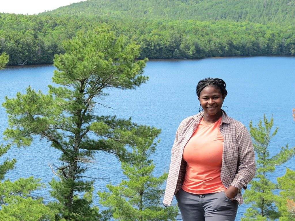 Nyeema Harris at the Huron Mountain Club, Upper Peninsula, Michigan. The background is a lake and trees.