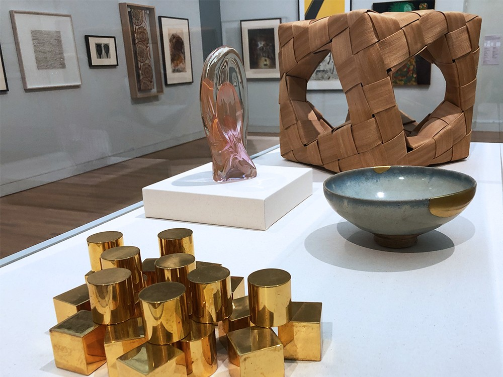 A table with four art objects: three twentieth century sculptures, and one stoneware object from the twelfth century. 