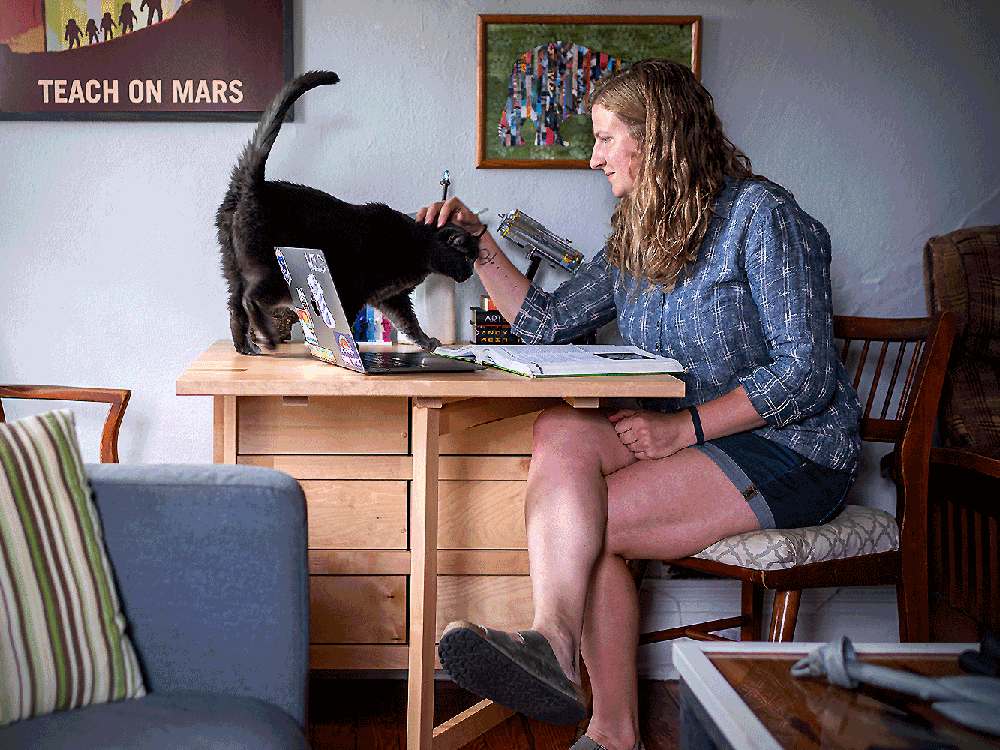 Lydia Pinkham studies at a table in her apartment with her cat Natasha.