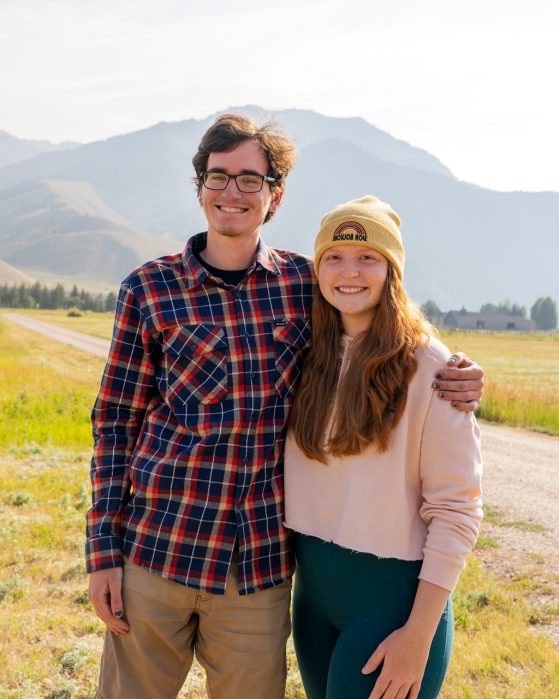 Trent and Savannah are pictured smiling against a mountainous backdrop.