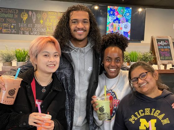 GSP RAs Zoe Zhou, David Henderson Sewit Yohannes, and Elina Mangel smile together at Quickly boba cafe for their final meeting