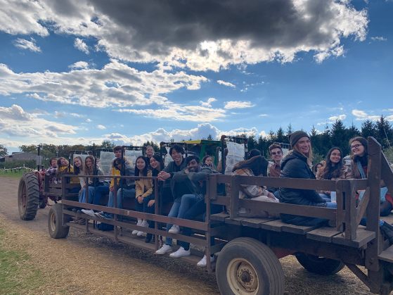 15+ GSP students smile from a wagon ride at Wiard’s Cider Mill