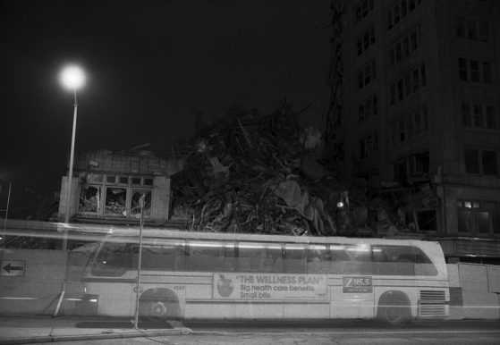 black and white photo of a bus at night