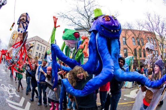 Many puppets being carried down the street during the annual FestiFools parade