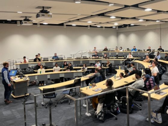 Students sit in a large classroom listening to Mark Stephenson standing at the front of the room