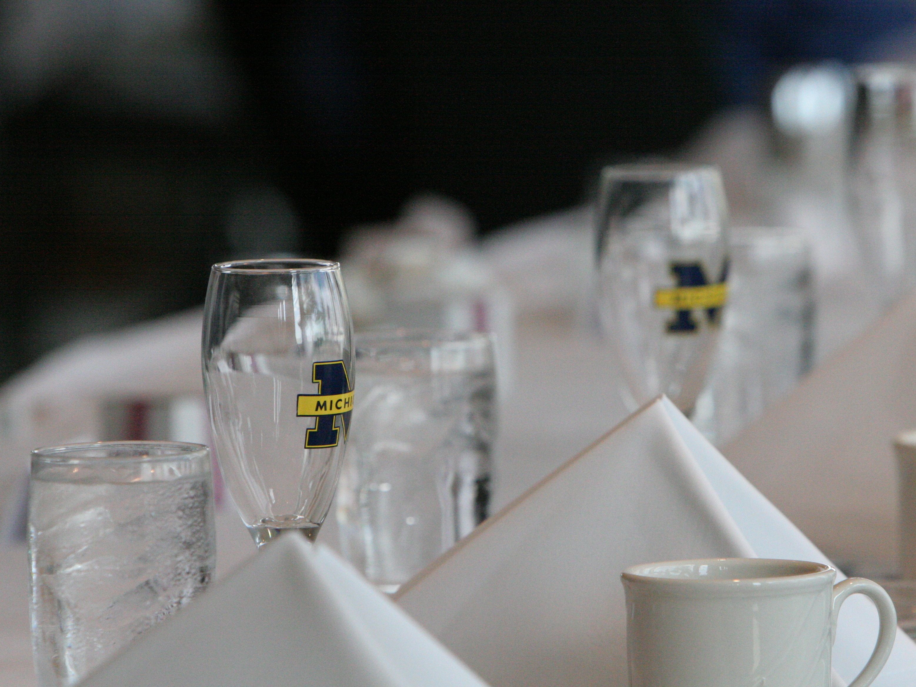 Champagne glasses and white napkins on a table with the block M logo