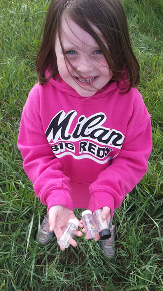 Girl holding insect collection vials