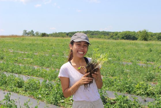 Jianella Macalino poses with a strawberry plant.