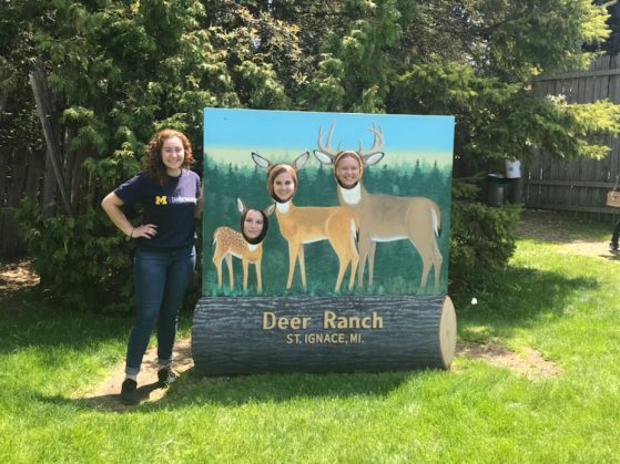 Students pose with a deer ranch sign.