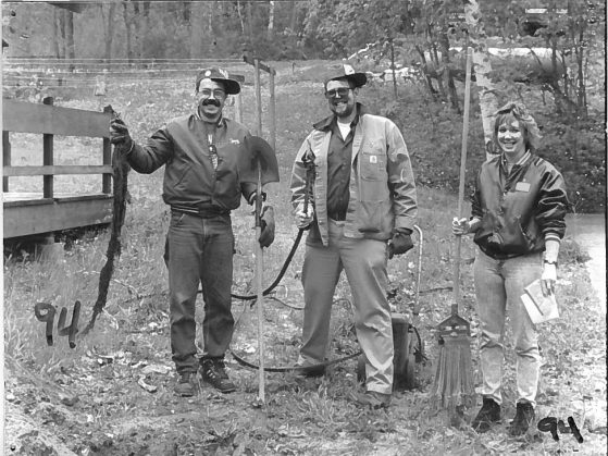 Tony Sutterley, Richard Spray, and Karen Bowman pose with their weapons of sewer maintenance in 1994.