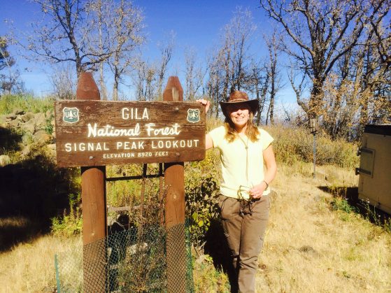 Alice stands in front of a Gila National Forest sign.