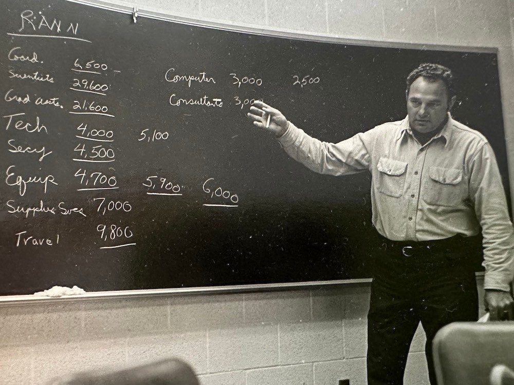 Man in front of chalkboard