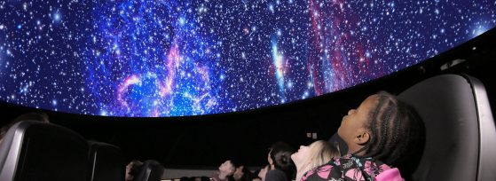 Kids looking at night sky inside the Planetarium