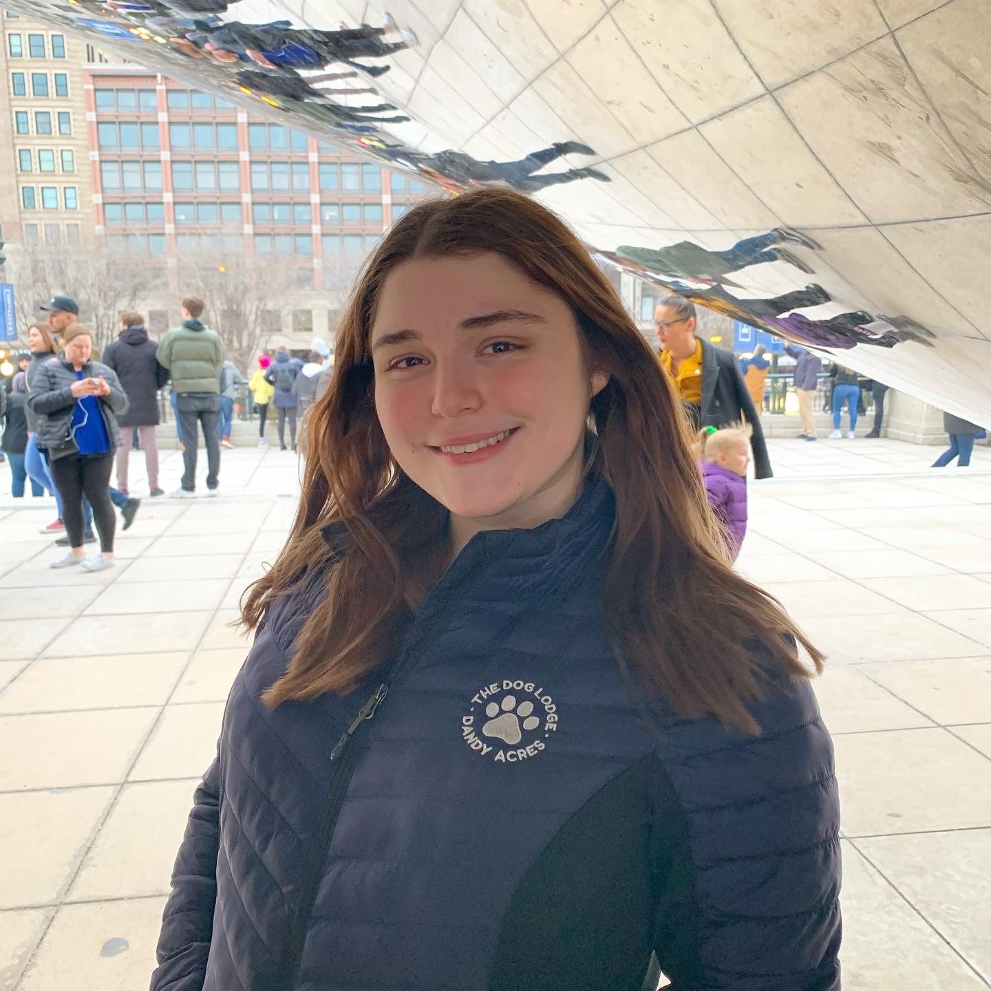 Alaina Lurie smiling and standing in front of a reflective structure