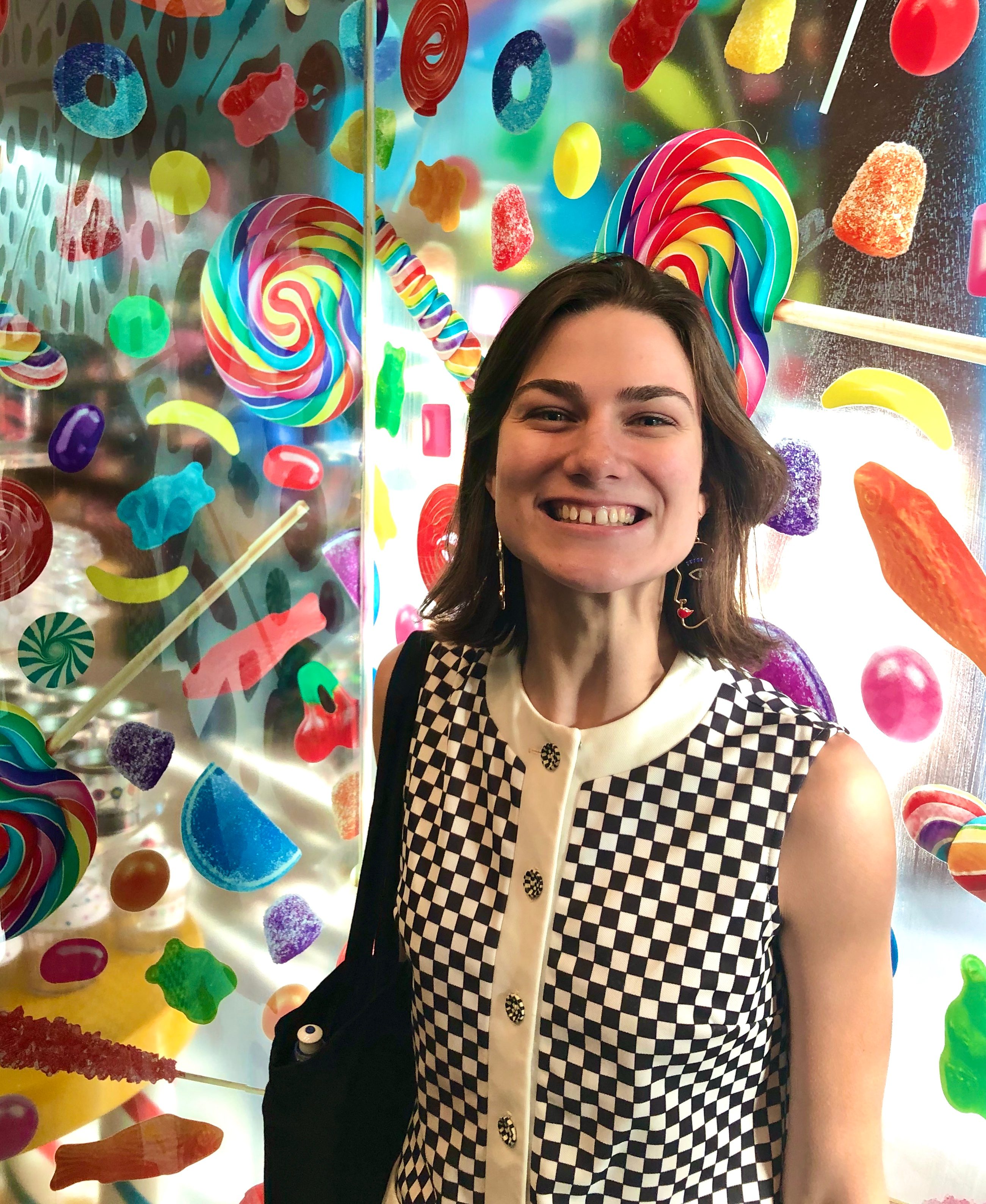 Rachel Kushner standing in front of a glass wall covered in candy stickers
