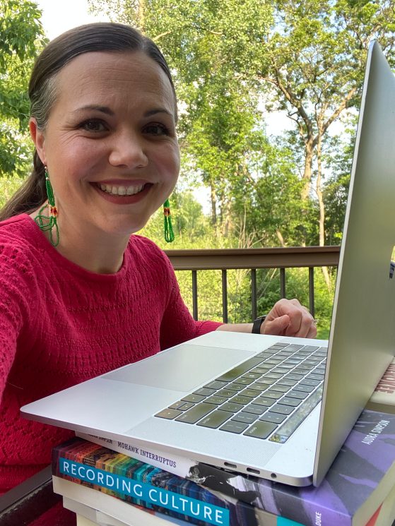 Dr. Bethany Hughes sitting at her computer outdoors