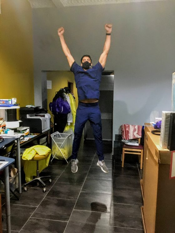 Person in scrubs celebrating by jumping in the air